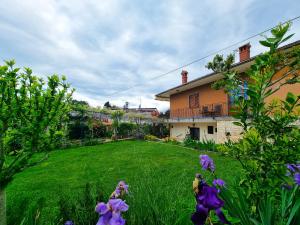a yard with purple flowers in front of a house at Bruno's Rooms in Bašanija