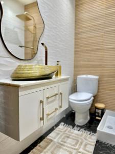 a bathroom with a toilet and a sink with a mirror at Luxury apartment Malabata in Tangier +19 photos