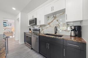 a kitchen with white cabinets and black appliances at Tipsy Turtle in Sanibel