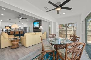 a living room with a ceiling fan and a table at Tipsy Turtle in Sanibel