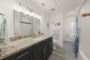 a bathroom with a sink and a large mirror at Tipsy Turtle in Sanibel