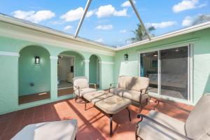 a porch with chairs and a couch and windows at Tipsy Turtle in Sanibel