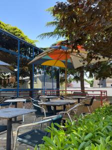 a group of tables and chairs with an umbrella at Hotel Arcantis Le Voltaire in Rennes
