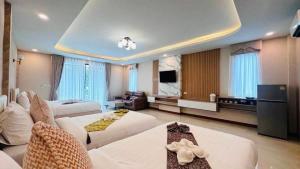 una grande camera d'albergo con due letti e una televisione di Colour Beach Resort a Ban Ro