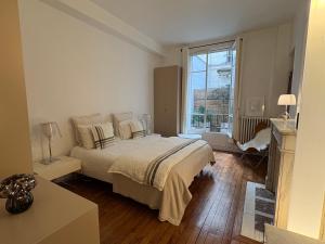 um quarto com uma cama e uma janela grande em Comme une maison à deux pas de l'Arc de Triomphe em Paris