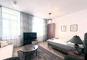 a bedroom with a bed and a tv and a couch at Zamojska Residence Silver Leaf Apartment in Lublin
