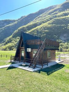 a small log cabin with a staircase in a field at Komarnica Forest Owl in Šavnik +31 photos