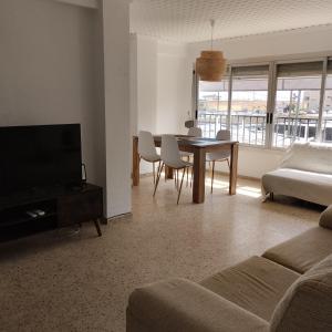 a living room with a couch and a table with chairs at Burrianna Beach Apartment in Burriana