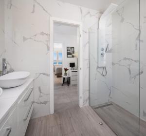 a white bathroom with a shower and a sink at Luxury penthouse with jacuzzi, panoramic view in Makarska +117 photos