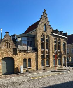 a large brick building with a garage on a street at Holiday home Nieuwpoort in Nieuwpoort