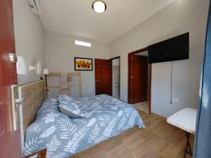 a bedroom with a bed and a flat screen tv at Playa Miel in Telchac Puerto