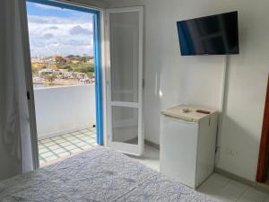 Un dormitorio con una cama y un televisor en una pared. en Casa Lipadusa, en Lampedusa