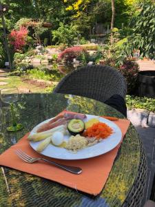 a plate of food with eggs and vegetables on a table at Le Jardin De La Tuilerie Alsace in Pfastatt