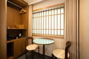 a small table and two chairs and a window at MAPLE MANSION Hongdae in Seoul