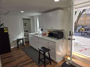 a kitchen with white cabinets and a counter with a microwave at Harvard Sq whole Unit 5min to campus w parking in Cambridge