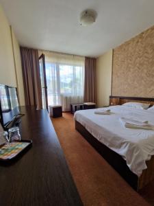 Una habitación de hotel con una cama grande y un escritorio. en Casa Bella, en Runcu