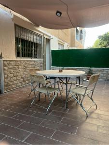 une table et des chaises assises sur une terrasse dans l'établissement Appartement Tout Confort Ifrane, à Ifrane 9 autres photos