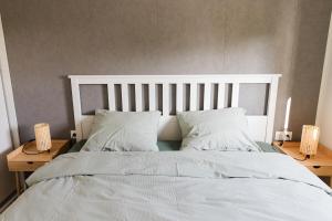 a bedroom with a large bed with white sheets and pillows at De Eend - Tiny house in de Zeeuwse Natuur in Driewegen