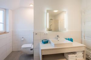 レーメにあるFerienhaus Uhlenhorstの洗面台とトイレを備えた白いバスルーム +8枚の写真