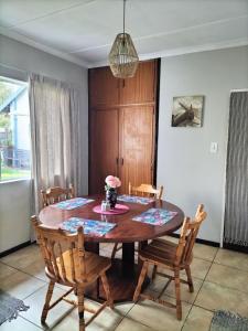 Un comedor con mesa y sillas de madera. en Howarth Hangar, en Kempton Park