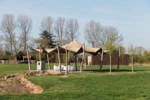 a tent in the middle of a field with trees at De Eend - Tiny house in de Zeeuwse Natuur in Driewegen