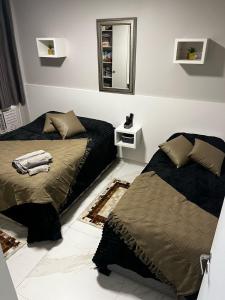 a bedroom with two beds and a mirror at Apto 1 dorm - San Francisco - localização perfeita in Balneário Camboriú