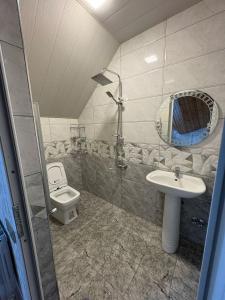 un baño con inodoro y lavabo en Sheki GuestHouse, en Sheki