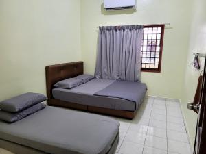 Postel nebo postele na pokoji v ubytování Pangkor Homestay