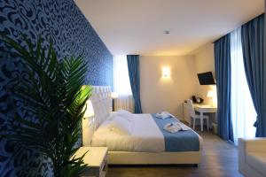 a hotel room with a bed and a plant at Hotel Palazzo Bello in Recanati