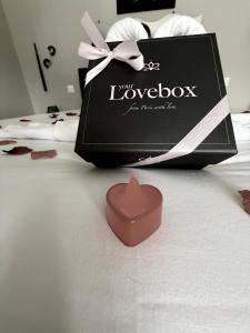 a box and a heart shaped candle on a bed at Charda Spa in Seyne