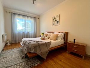 a bedroom with a bed with a dresser and a window at Golf and Beach Serenity in Aroeira