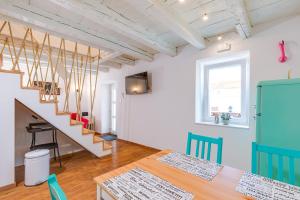 a dining room with a table and a staircase at Kuća Koza-Apartment Elisa in Punat
