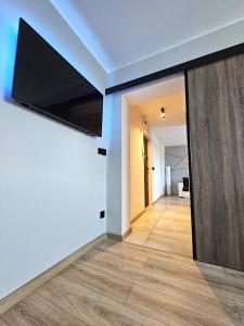ピエホビツェにあるApartament Novoczesny - Self check-inの壁に薄型テレビが取り付けられたリビングルーム