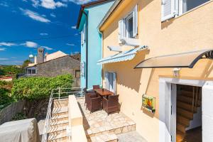 a balcony of a house with two chairs at Kuća Koza-Apartment Elisa in Punat