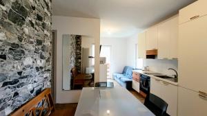 a kitchen and living room with a stone wall at Casa Degara in Ledro