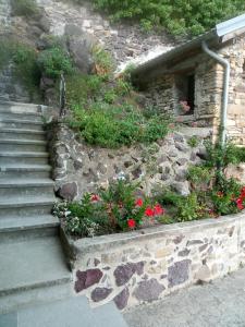 a set of stairs with flowers in a stone wall at BARDI AL RIOLO la QUERCIA in Bardi
