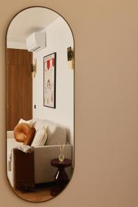 espejo que refleja un sofá en la sala de estar en Lavie Maison Marais Sauna Hot Tub, en París 18 fotos más