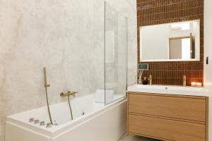 um banheiro com banheira, pia e espelho em Lavie Maison Glass Roof Flat- AC Hot Tub em Paris