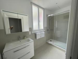 a white bathroom with a sink and a shower at Art Hotel Ristorante Posta Al Lago in Ronco s/Ascona - Porto Ronco +65 photos