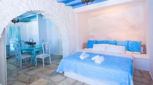 una camera da letto con un letto blu e un tavolo di Villa Boufla ad Agios Ioannis