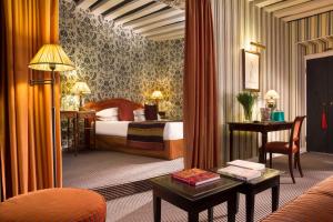 una habitación de hotel con una cama y un escritorio en Hotel Résidence Des Arts - Saint-Germain, en París
