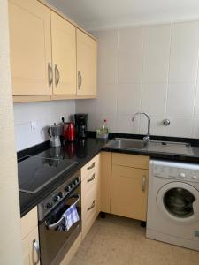 une cuisine avec un évier et une machine à laver dans l'établissement House with garden at Oliva Nova MET & Golf & Padel & Beach resort, à Casas Devesa