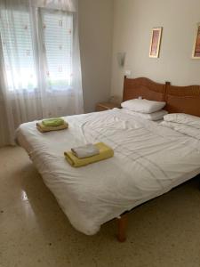 un lit blanc avec deux serviettes dessus dans l'établissement House with garden at Oliva Nova MET & Golf & Padel & Beach resort, à Casas Devesa 18 autres photos