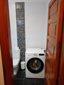 a washing machine in a bathroom with a toilet at Parque Santiago II 379 Tenerife Rental & Sales in Playa de las Americas
