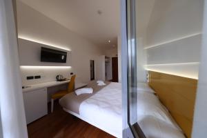 a bedroom with a bed and a desk and a tv at Hotel Palazzo Bello in Recanati