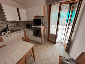 a kitchen with white cabinets and a table with a computer at Leopardi 81 - 400 mt dall' AUTODROMO F1 in Imola