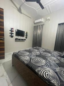 a bedroom with a bed with a television on the wall at Independent House, 2 Bedroom, 2 Bath Livingroom,Lobby,kitchen,car parking in Amritsar