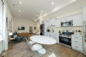 a kitchen with white cabinets and a table and chairs at Modern Loft-Style Retreat Near Blenko Glass in Milton, WV in Hurricane +22 photos