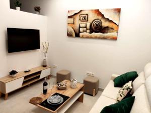 a living room with a couch and a tv at El Capricho de Vandelvira in Úbeda