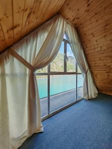 a room with a window with a view of the water at Riverside Komani Lake in Koman